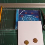 Una caja de c-d cartulina,tijeras,lapiz,monedas diferentes,regla